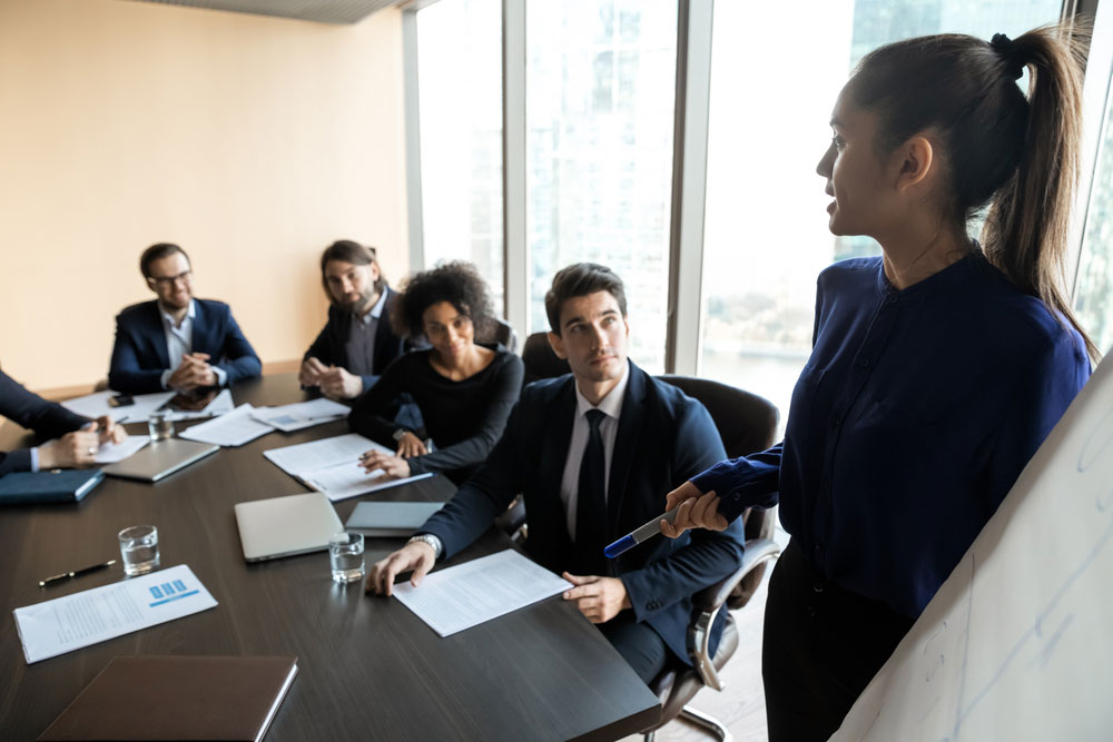 Business person uses strategic communication skills during a boardroom presenation