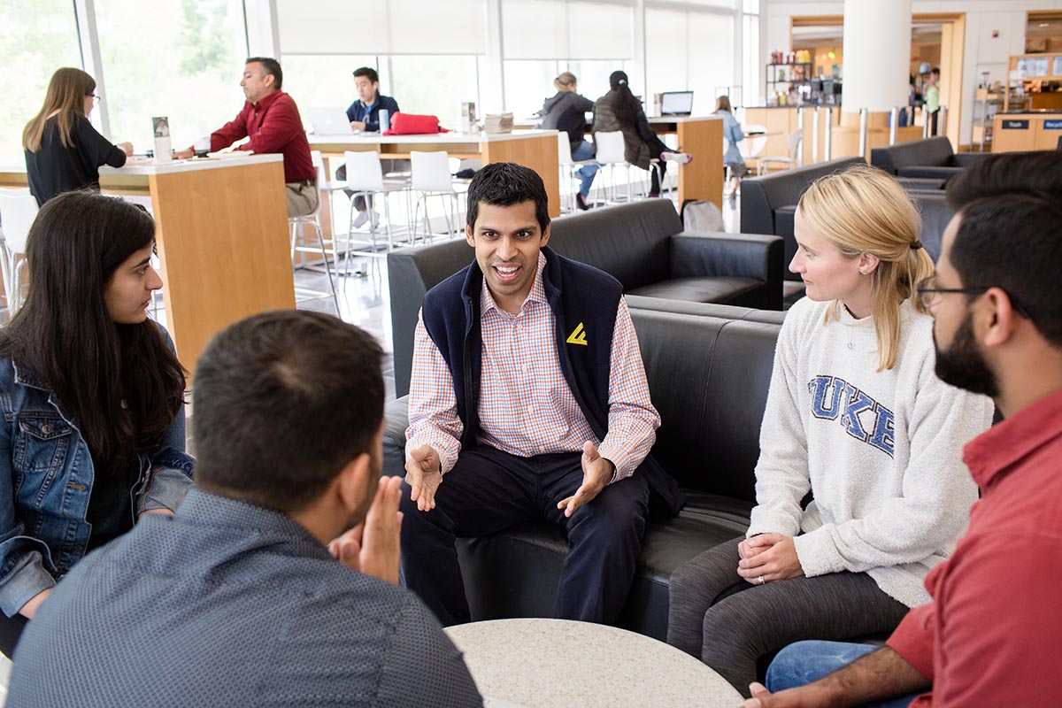 Professor Aaron Chatterji sitting with students