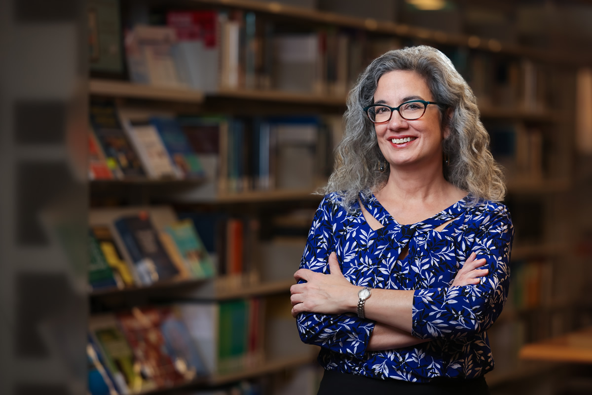 Interim Dean Mary Frances Luce standing in front of bookshelves