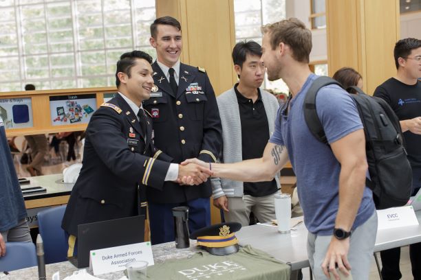 Member of the Duke Armed Forces Association shaking hands with a student